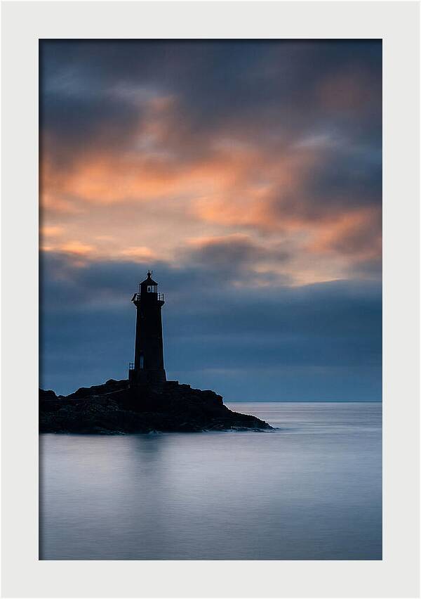 Lighthouse Silhouetted Against Dramatic Sky