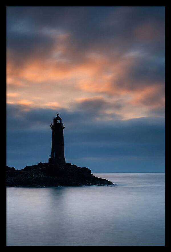 Lighthouse Silhouetted Against Dramatic Sky