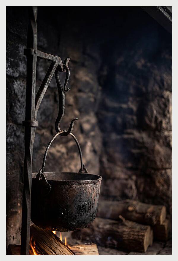 Old Iron Cauldron Hanging In Kitchen