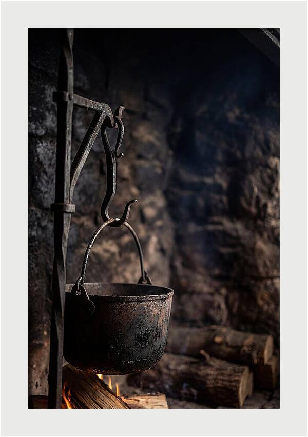 Old Iron Cauldron Hanging In Kitchen