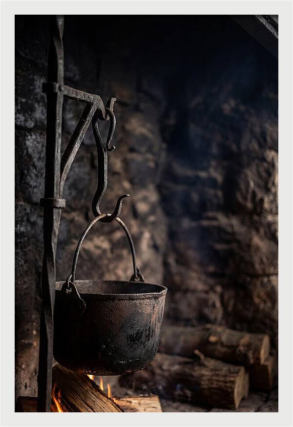 Old Iron Cauldron Hanging In Kitchen