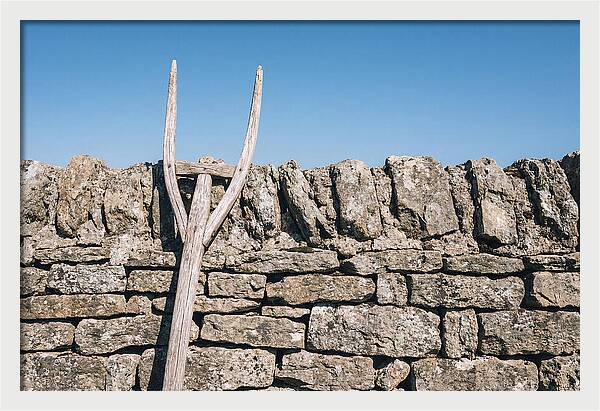 Old Wooden Hay Fork Against Stone Wall
