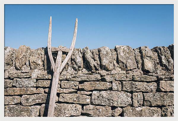 Old Wooden Hay Fork Against Stone Wall