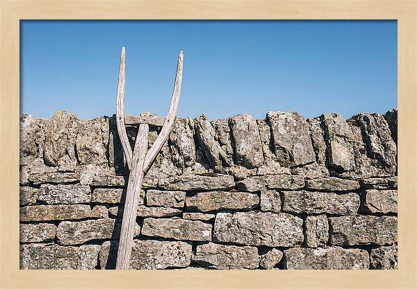 Old Wooden Hay Fork Against Stone Wall