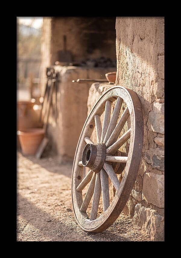 Old Wooden Wheel Against Wall