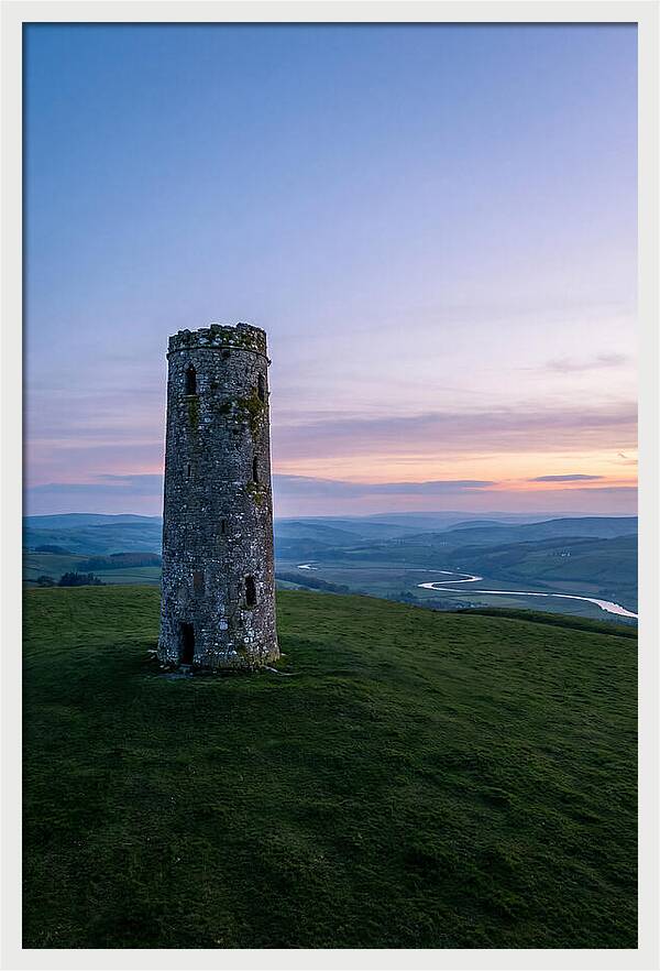 Round Stone Tower On Green Hillside