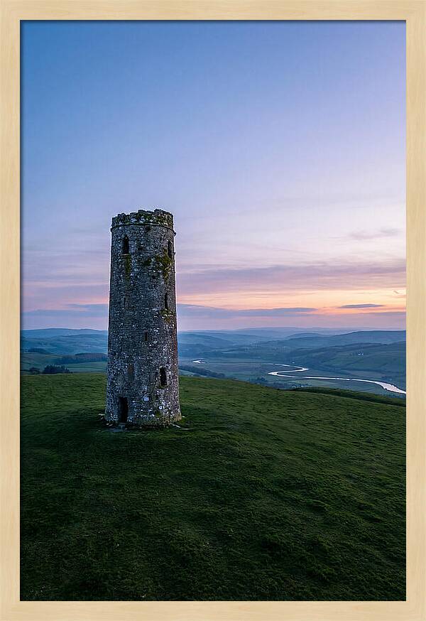 Round Stone Tower On Green Hillside
