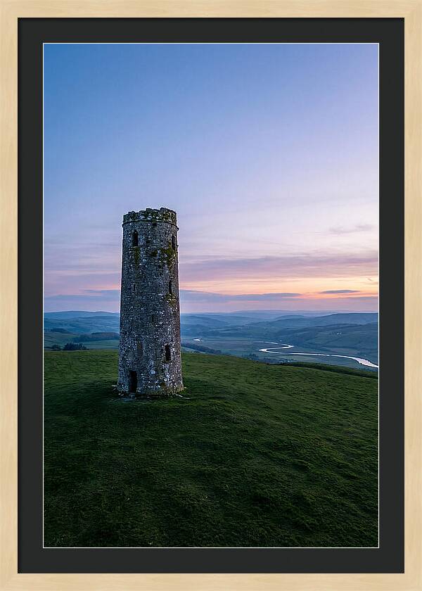 Round Stone Tower On Green Hillside