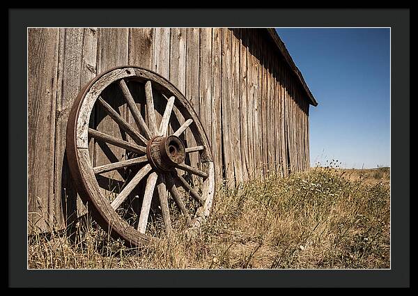 Weathered Wagon Wheel Against Barn