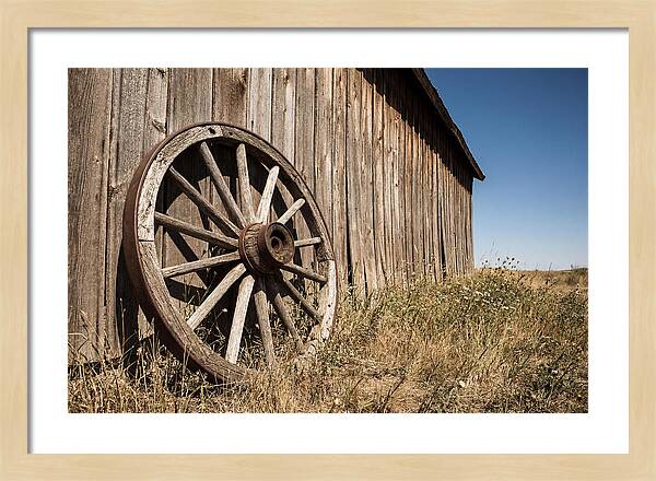 Weathered Wagon Wheel Against Barn