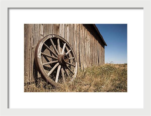 Weathered Wagon Wheel Against Barn